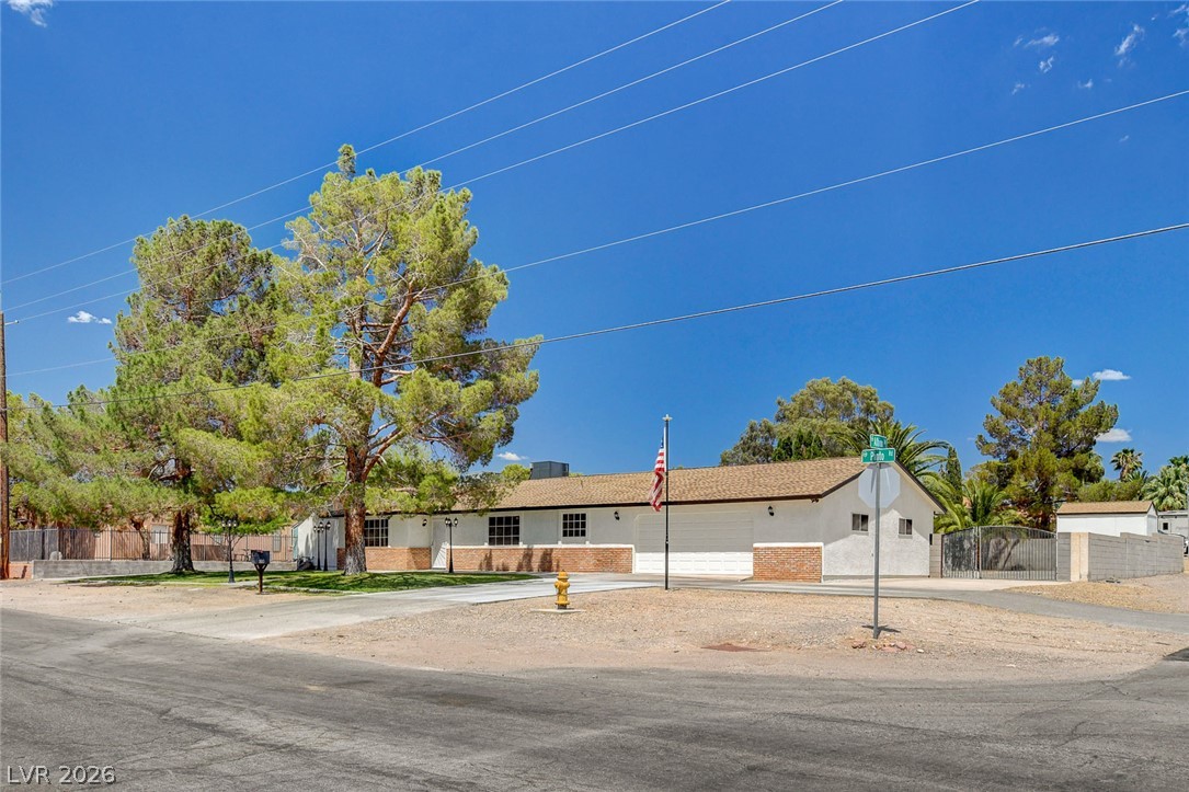 1810 Pinto Road Henderson, NV 89002 - Photo 4 of 53 Discover a charming single-story residence with a neatly kept front facade and mature trees.