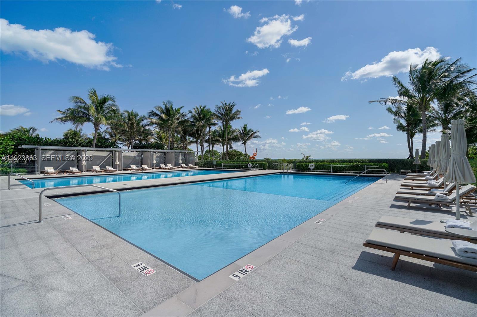8701 Collins Avenue, Unit 902 Miami Beach, FL 33154 - Photo 20 of 24 a view of a swimming pool with lounge chair