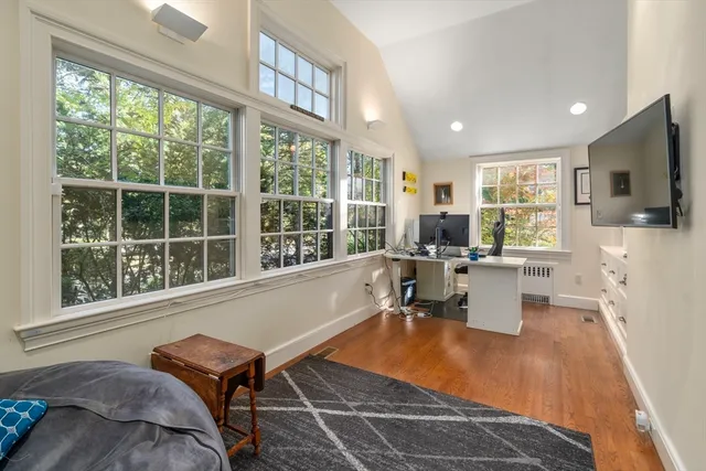 a living room with furniture a flat screen tv and a large window