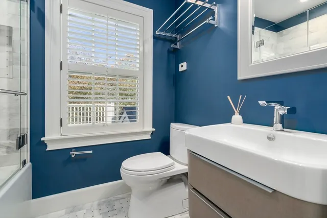 a bathroom with a sink a toilet and a window