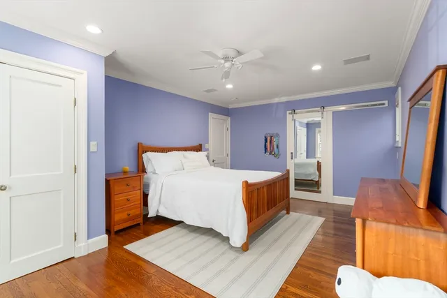 a spacious bedroom with a bed and wooden floor