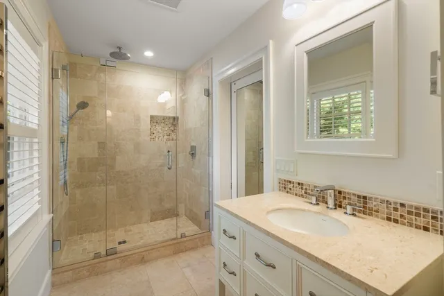 a bathroom with a granite countertop sink mirror and shower