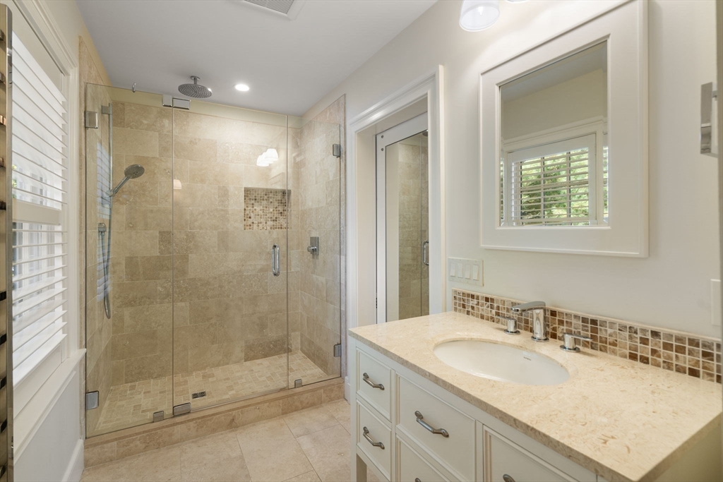 131 Oliver Road Newton, MA 02468 - Photo 21 of 33 a bathroom with a granite countertop sink mirror and shower