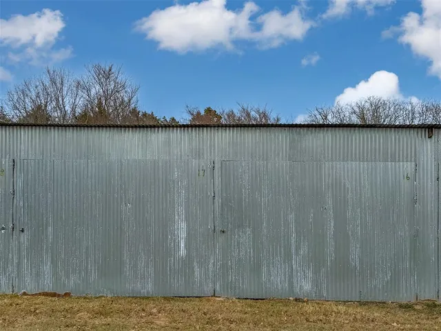 a spacious bedroom with a bed a table chair and glass door
