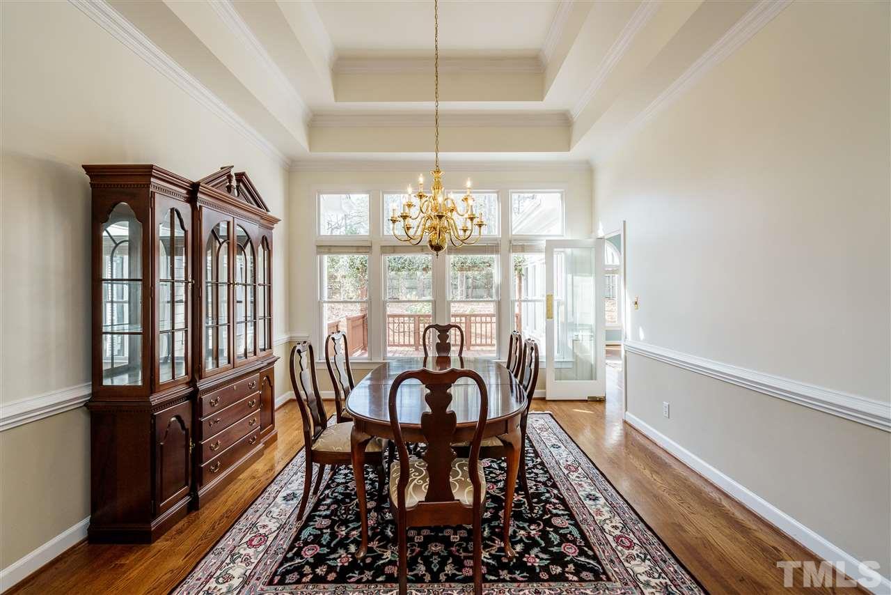 412 Chatterson Drive Raleigh, NC 27615 - Photo 8 of 30 Formal Dining Room features a wall of windows that look out upon the Deck +beautifully - landscaped back yard. This room is large enough for placement of several serving + storage pieces in addition to a large table. A swinging door accesses Kitchen.