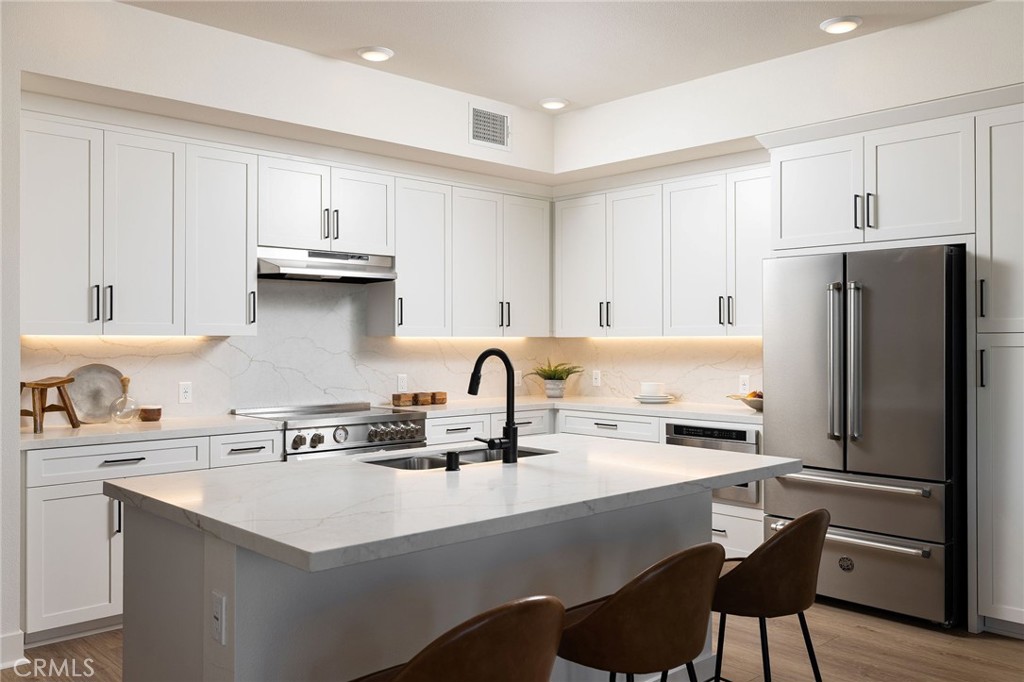 414 Main Street, Unit 330 Huntington Beach, CA 92648 - Photo 14 of 42 a kitchen with stainless steel appliances a sink a stove and a refrigerator