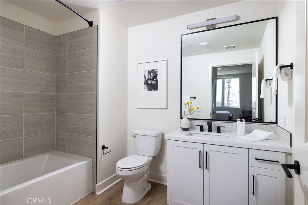 414 Main Street, Unit 330 Huntington Beach, CA 92648 - Photo 17 of 42 a bathroom with a bathtub a sink mirror and toilet
