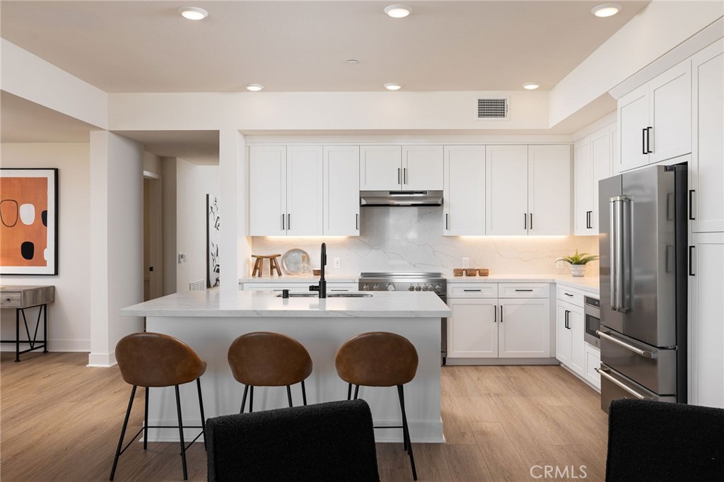 414 Main Street, Unit 330 Huntington Beach, CA 92648 - Photo 9 of 42 a kitchen with refrigerator cabinets dining table and chairs