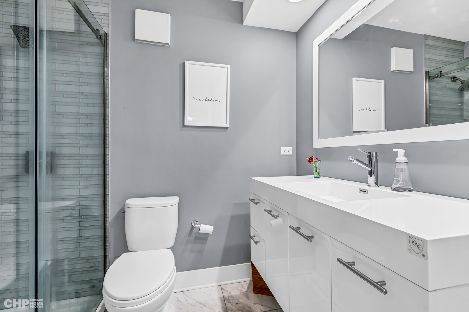 111 East Chestnut Street, Unit 49H Chicago, IL 60611 - Photo 20 of 27 a bathroom with a toilet sink vanity and mirror