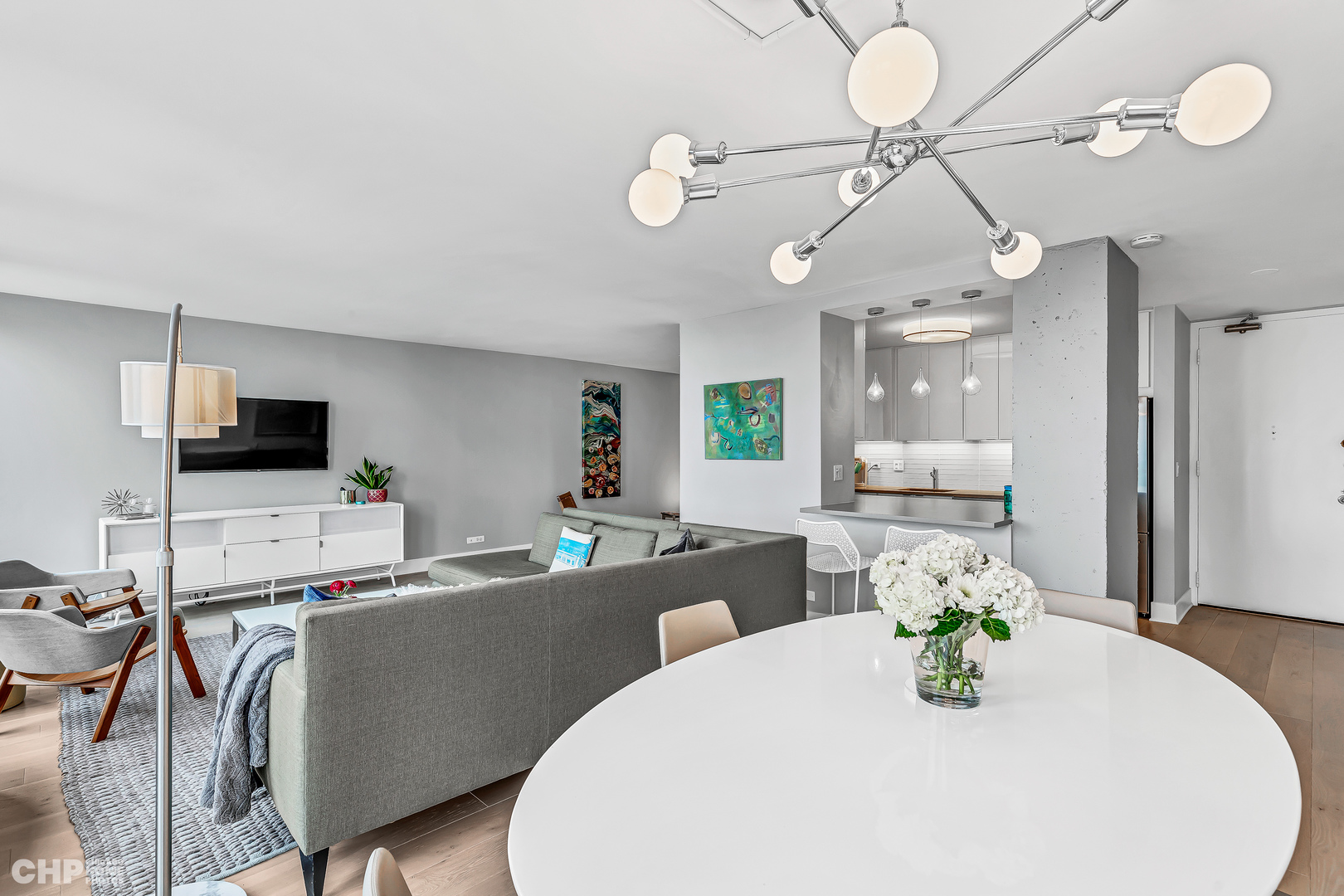 111 East Chestnut Street, Unit 49H Chicago, IL 60611 - Photo 6 of 27 a kitchen with stainless steel appliances kitchen island granite countertop a sink a stove a dining table and chairs with wooden floor
