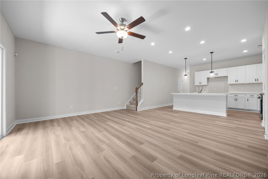 232 Elijah Way, Unit 8 Vass, NC 28394 - Photo 15 of 41 a view of a kitchen with kitchen island a sink wooden floor and stainless steel appliances
