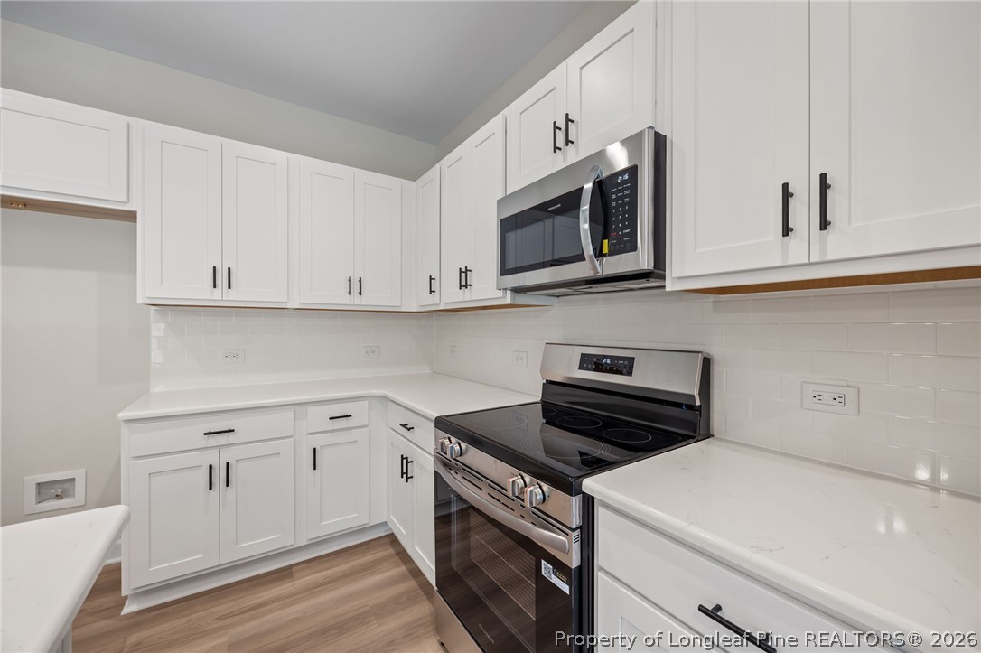232 Elijah Way, Unit 8 Vass, NC 28394 - Photo 10 of 41 a kitchen with white cabinets stainless steel appliances and sink
