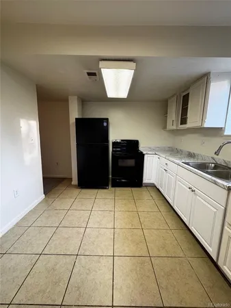a kitchen with granite countertop a refrigerator and a stove top oven