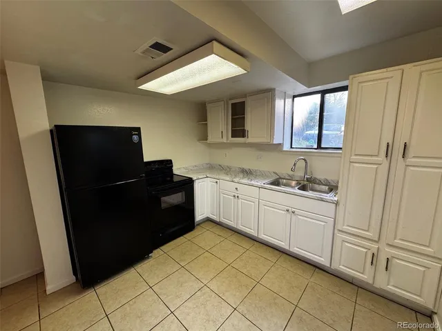 a kitchen with a refrigerator and white cabinets
