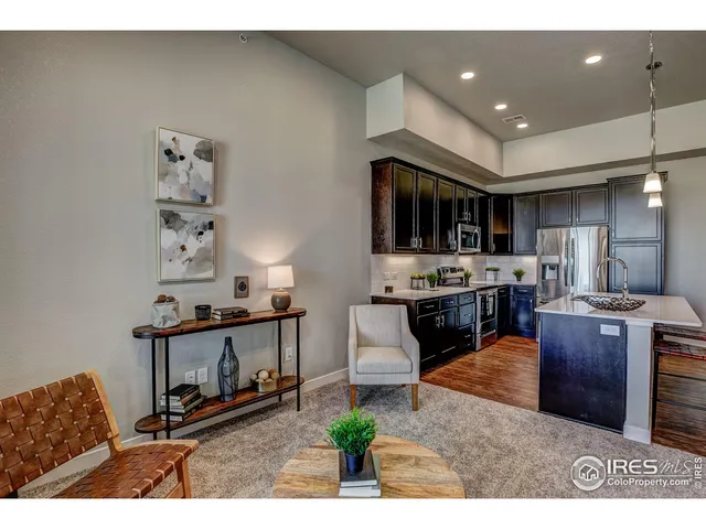 a living room with stainless steel appliances kitchen island granite countertop furniture a rug and a window