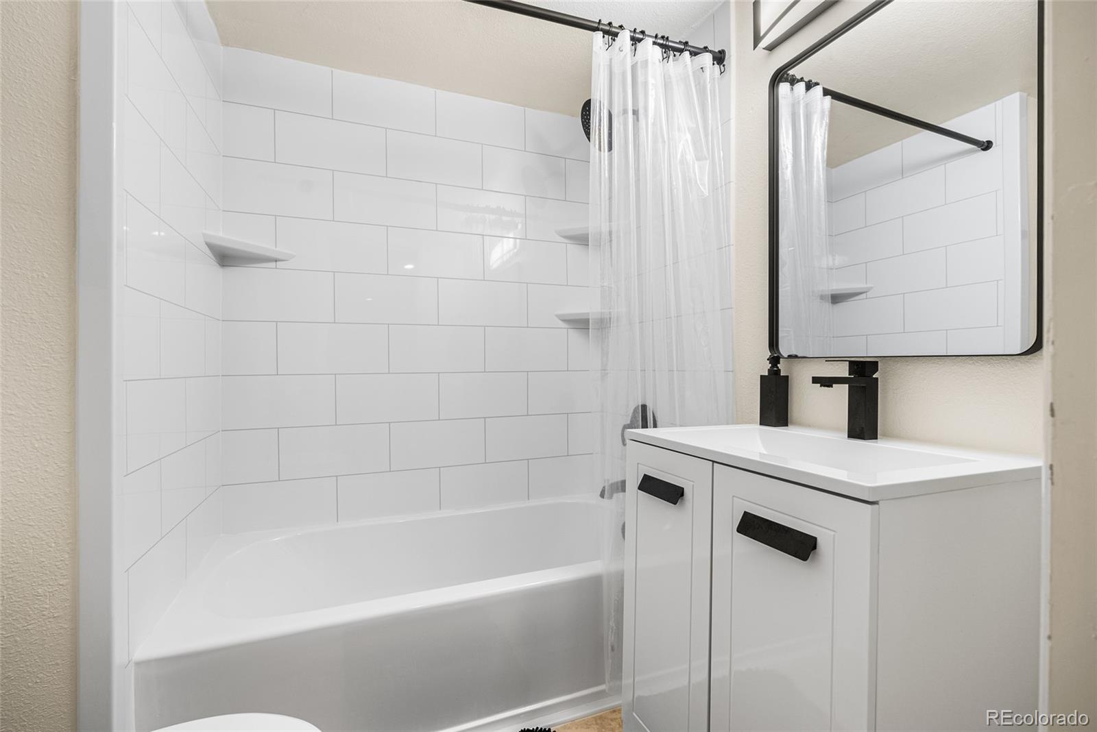 4546 Meade Street Denver, CO 80211 - Photo 17 of 35 a white bath tub sitting next to a white sink and vanity