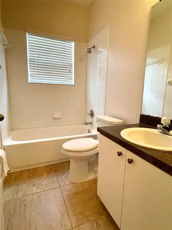 a bathroom with a granite countertop sink toilet a mirror and bathtub