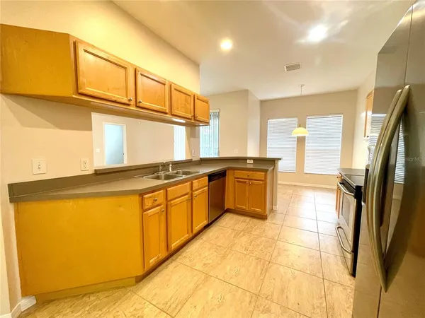 a large kitchen with stainless steel appliances granite countertop a stove a sink and a refrigerator