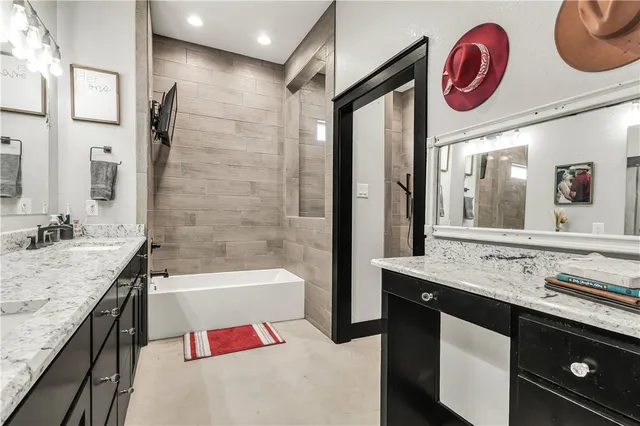 a bathroom with a granite countertop sink a large mirror and a bathtub
