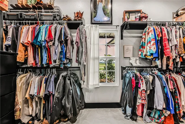 a view of walk in closet with clothes and shoes