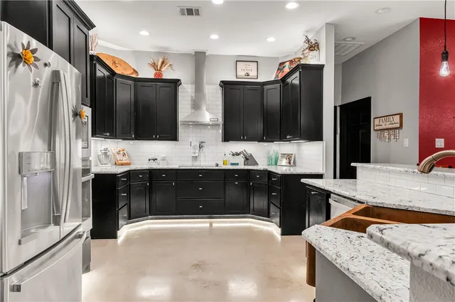 a large kitchen with stainless steel appliances kitchen island granite countertop a refrigerator stove and sink