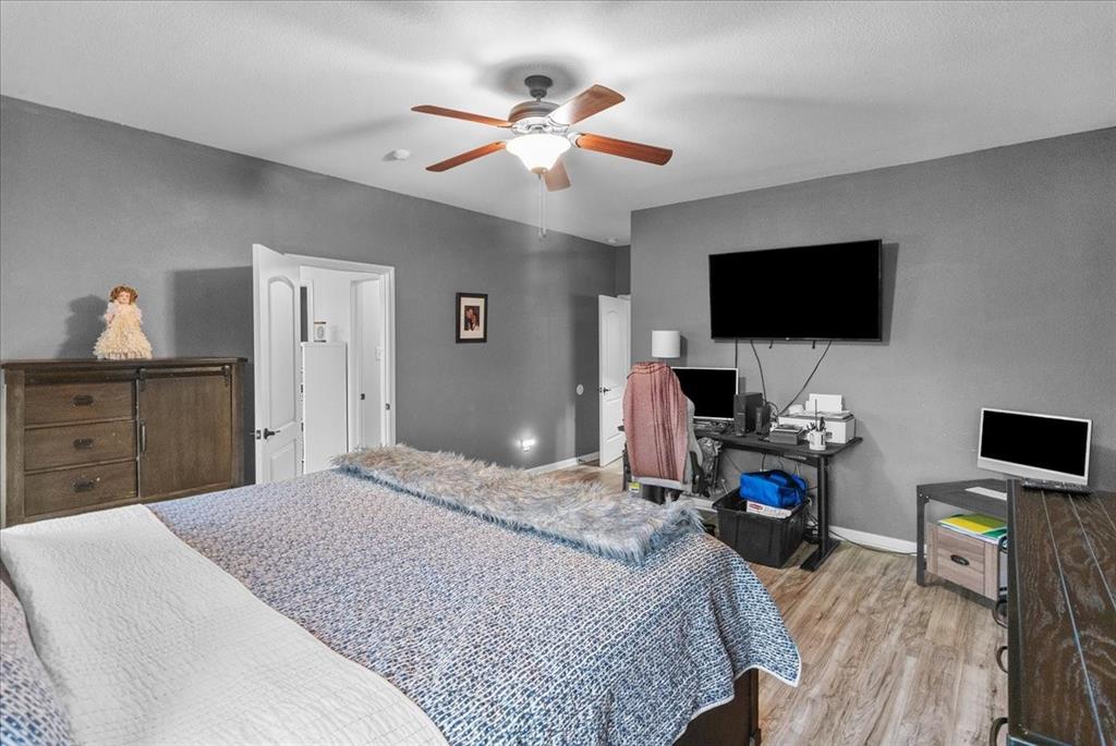 2529 Spring Meadows Drive Denton, TX 76209 - Photo 18 of 29 a bedroom with a bed and a flat screen tv