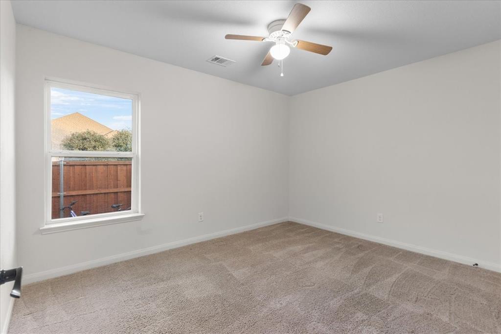 2529 Spring Meadows Drive Denton, TX 76209 - Photo 23 of 29 an empty room with a window and ceiling fan