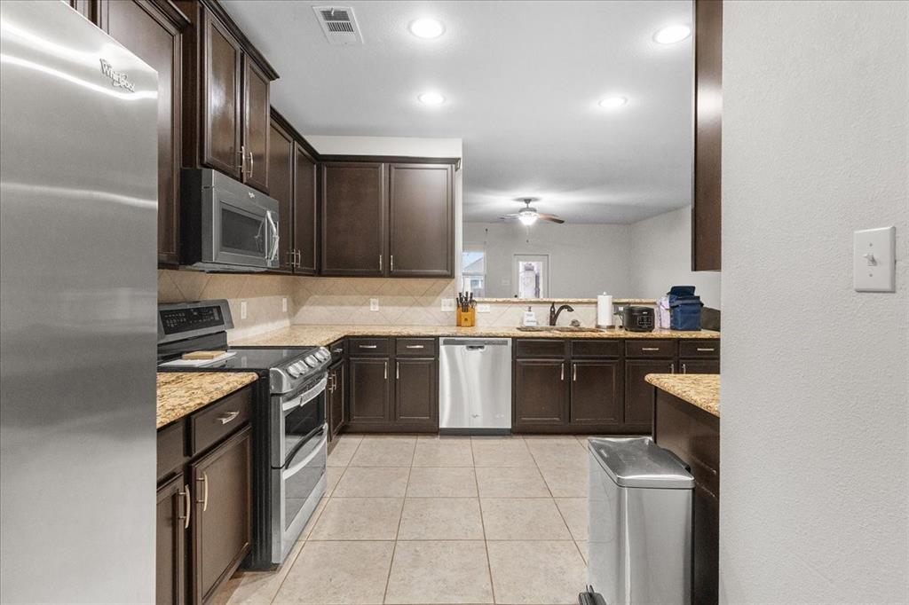 2529 Spring Meadows Drive Denton, TX 76209 - Photo 7 of 29 a kitchen with a sink stove and oven