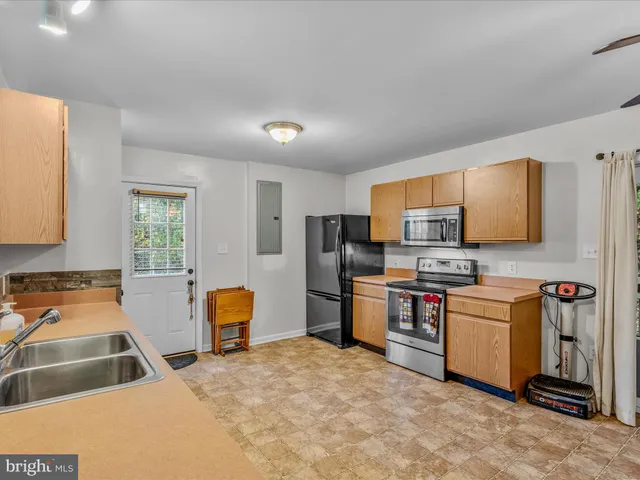 a kitchen that has a lot of cabinets and refrigerator
