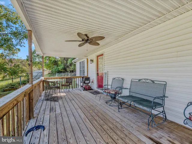 a balcony with wooden floor and outdoor seating