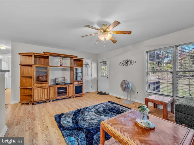 a living room with furniture a flat screen tv and a large window