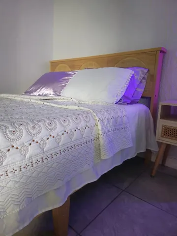 a bed sitting in a bedroom next to a blue wall