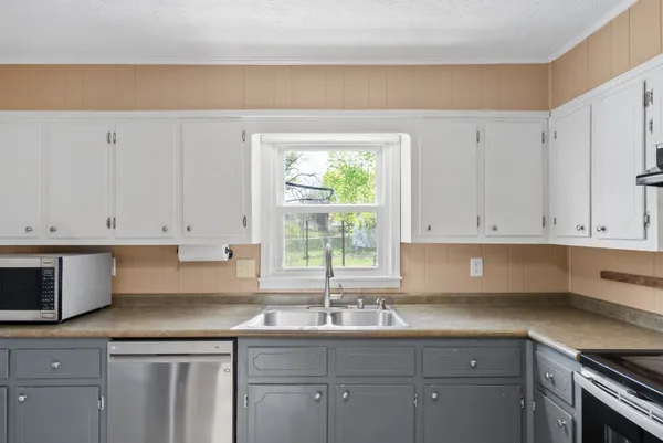 a kitchen with granite countertop white cabinets and window