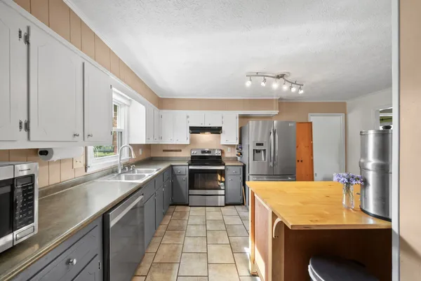 a kitchen with a stove sink and cabinets