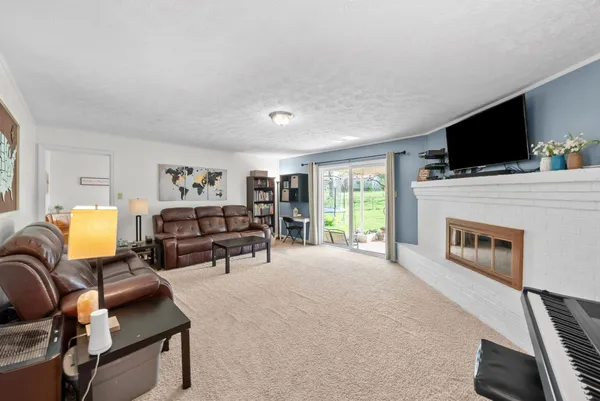 a living room with furniture a flat screen tv and a fireplace