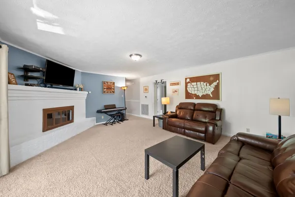 a living room with furniture a fireplace and a flat screen tv