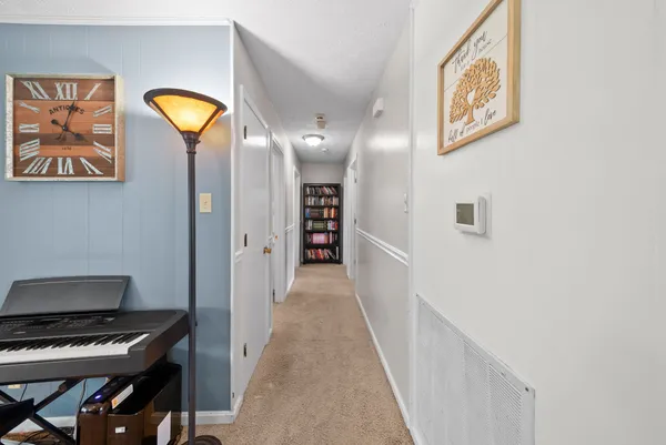a view of a hallway to a livingroom with furniture
