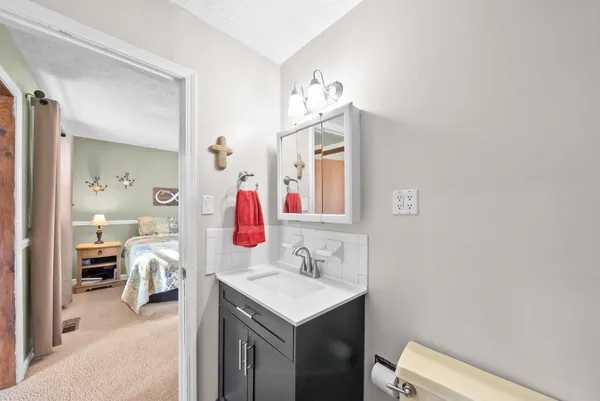 a en suite bathroom with a sink vanity and mirror