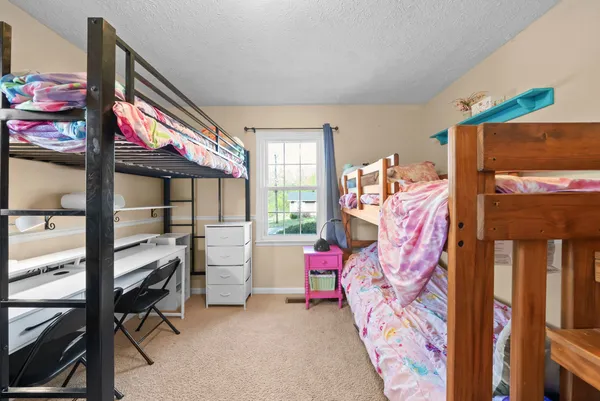 a bedroom with bunk bed and a window