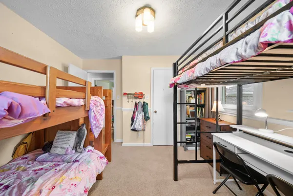 a bedroom with a bed next to a window