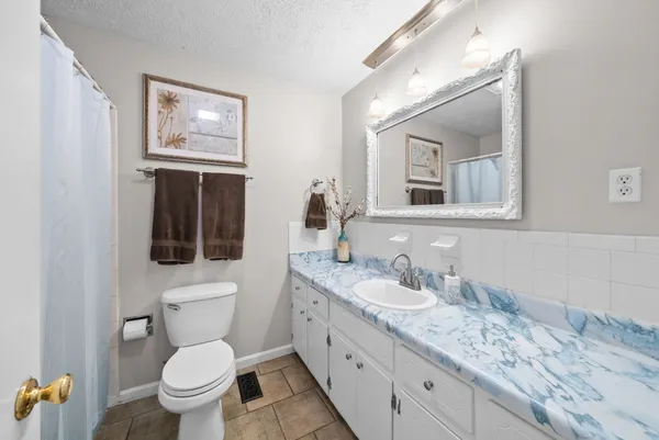 a bathroom with a toilet a sink and mirror