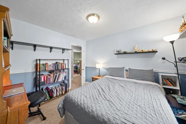 a bedroom with a bed and a book shelf