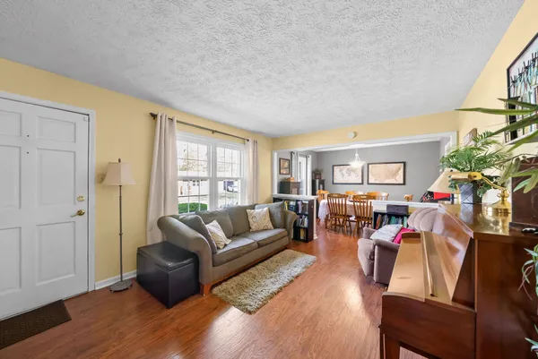 a living room with furniture wooden floor and a large window