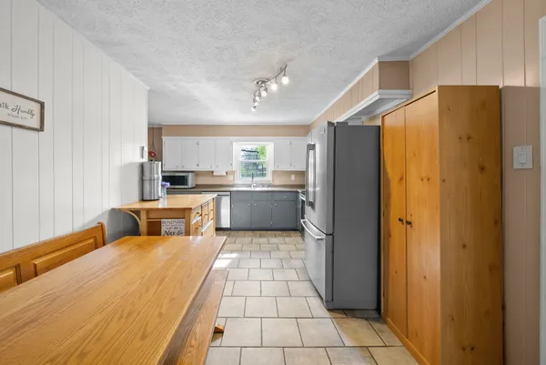 a large kitchen with a refrigerator and a sink