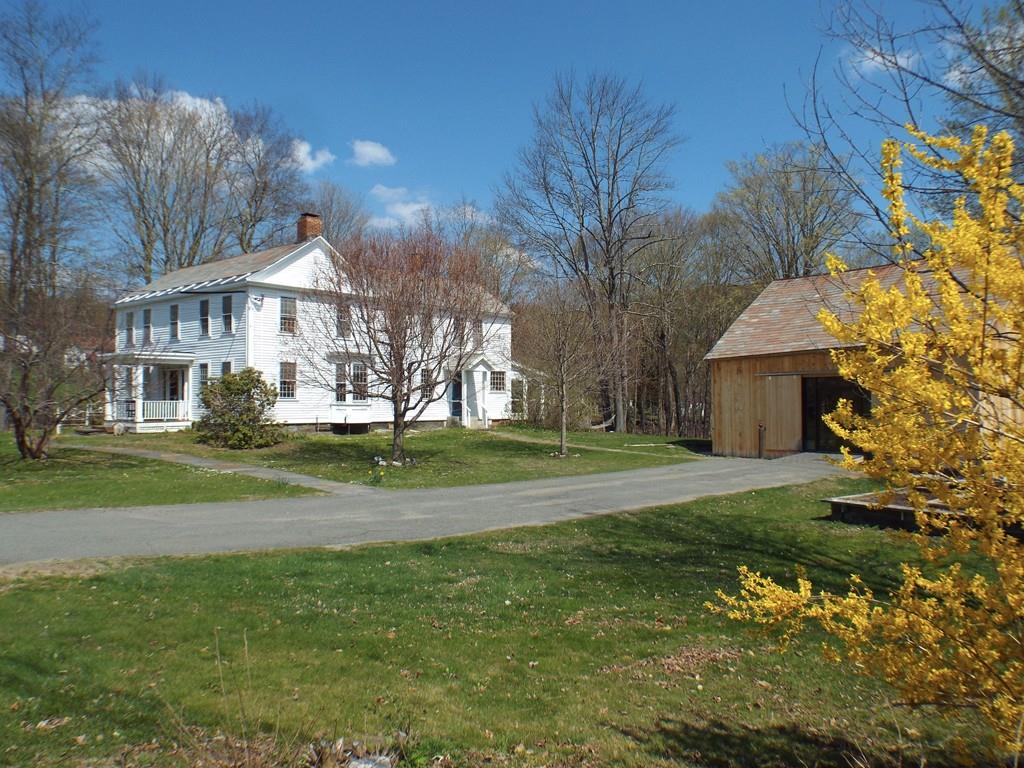 a view of a big house with a big yard and large trees