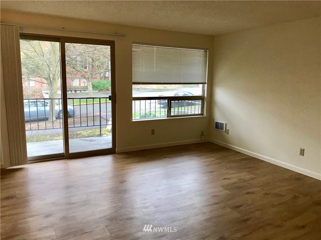 3912 Linden Avenue North Seattle, WA 98103 - Photo 6 of 11 a view of an empty room with wooden floor and a window
