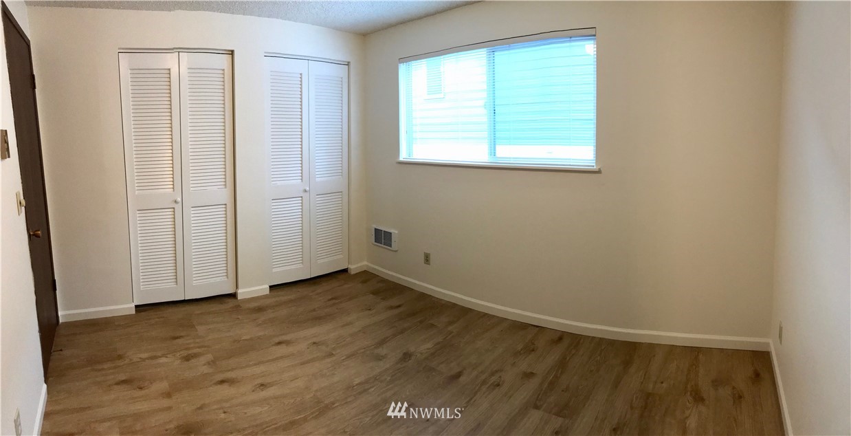 3912 Linden Avenue North Seattle, WA 98103 - Photo 10 of 11 an empty room with wooden floor and windows