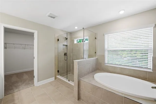 a large bathroom with a double vanity sink a large mirror and shower