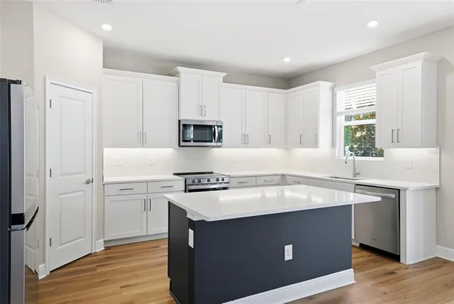 a kitchen with a sink stove top oven and refrigerator