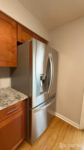 a metallic refrigerator freezer sitting inside of a kitchen